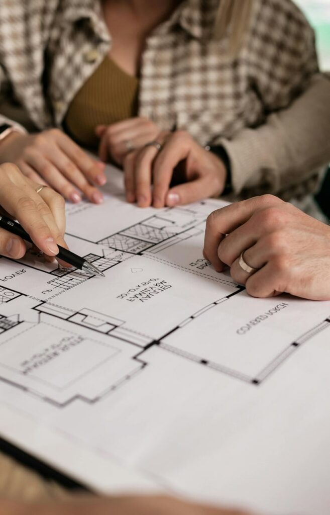 Nahaufnahme mehrerer Hände von Personen, die sich Objektunterlagen anschauen